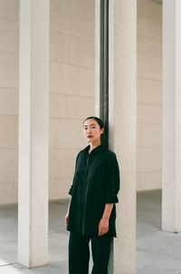 Portrait of woman standing against wall