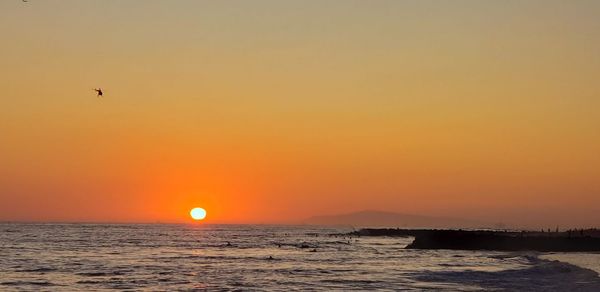 Scenic view of sea against orange sky