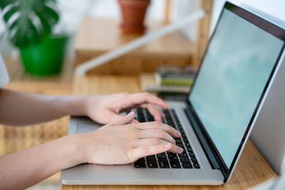 Female hands typing on notebook keyboard studying working with pc  online education , close up view