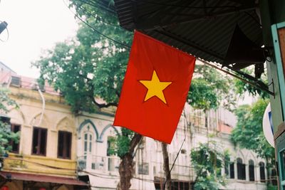 Low angle view of vietnamese flag hanging on building