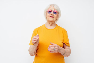 Portrait of young woman with arms crossed against white background