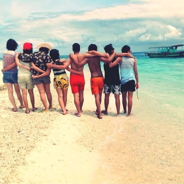 beach, sea, lifestyles, leisure activity, water, sand, sky, shore, togetherness, person, vacations, cloud - sky, men, rear view, childhood, casual clothing, standing, boys