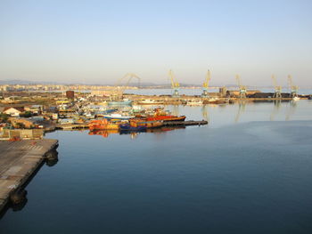 Commercial dock by sea against clear sky