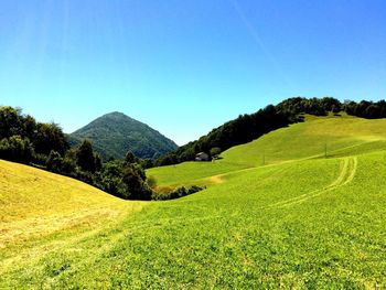 Scenic view of hills and mountain against clear blue sky