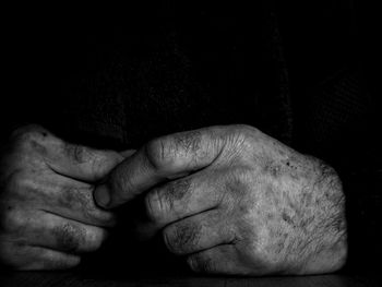 Close-up of hands against black background