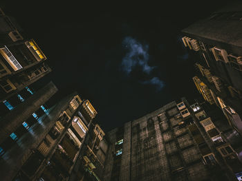 Low angle view of illuminated buildings against sky at night