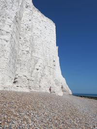 Rear view of people on rock against sky