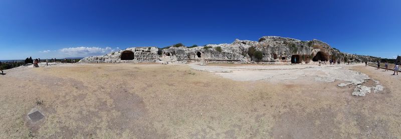 View of rocks against clear blue sky