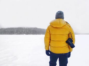 Rear view of man standing against clear sky