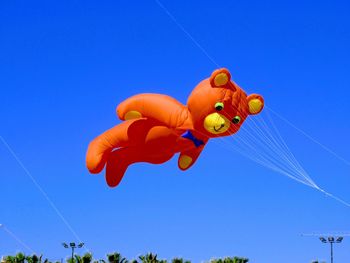 Low angle view of orange fruits against blue sky