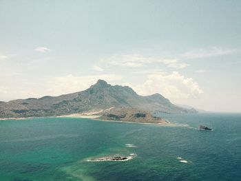 Scenic view of sea and mountains against sky