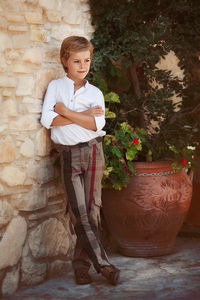 Boy looking away against wall