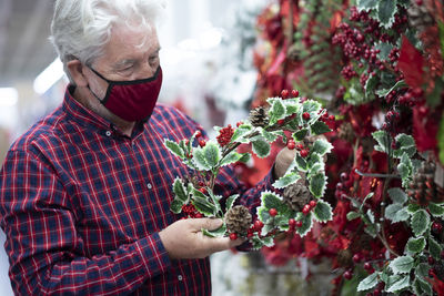 Midsection of man holding red flowers