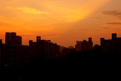 Silhouette cityscape against sky during sunset