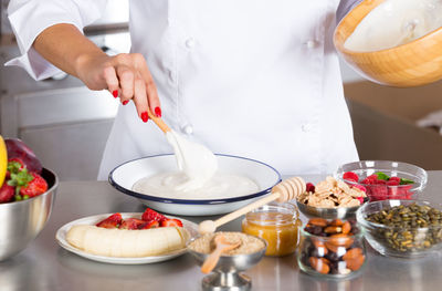 Midsection of chef preparing food in commercial kitchen