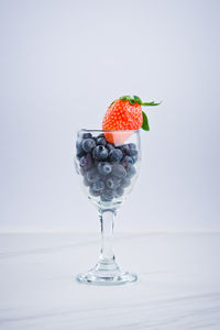 Close-up of strawberry on table against white background