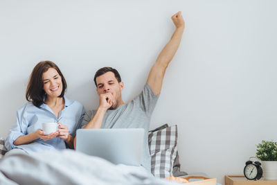 Couple waking up on bed at home