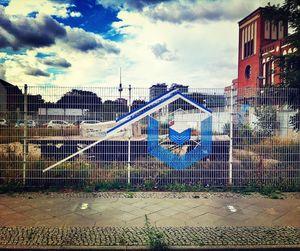 Chainlink fence against cloudy sky