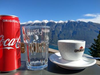 Coffee cups on table by mountains