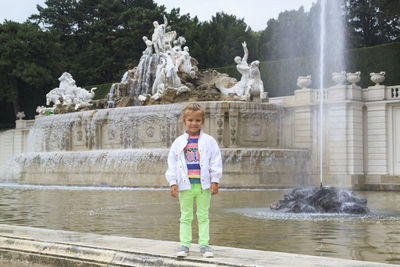 Portrait of boy standing against fountain