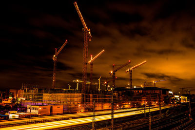 Firework display over city against sky at night