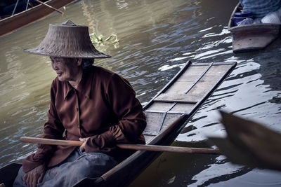 Man sitting on boat in river