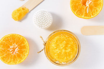 Sugar scrub with orange pieces on a white background, top view. beauty procedures for peeling 