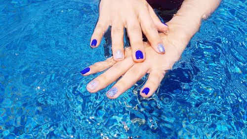 High angle view of woman hands in swimming pool