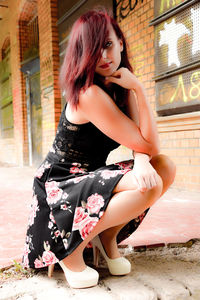 Young woman looking down while sitting outdoors