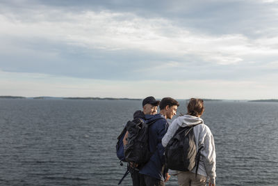 Friends standing together at sea