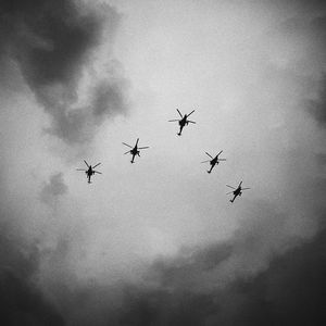 Low angle view of silhouette birds flying against sky