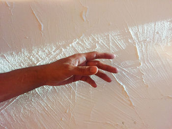 Close-up of hands against wall