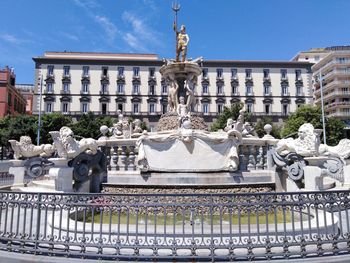Statue of fountain against buildings in city