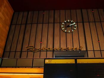 Low angle view of clock hanging on ceiling in building