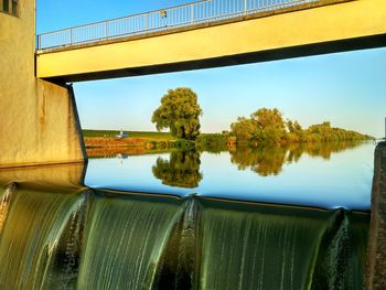 Reflection of bridge on lake against sky