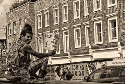 People on street by buildings in city