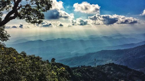 Scenic view of mountains against cloudy sky