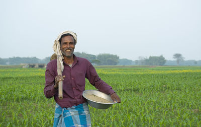 Farmer standing in field with spade and basket