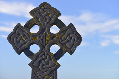 Low angle view of cross against sky