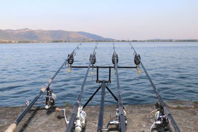 Fishing by scenic view of lake against sky