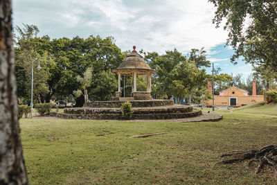 Old stone architecture build with trees around on background and beautiful green field