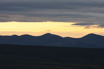 Scenic view of silhouette mountains against sky during sunset