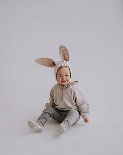 Toddler baby boy in funny bunny costume sitting and looking at the camera