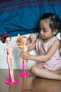 Young asian kid at home playing fashion doll. child in kindergarten. kid in nursery school.