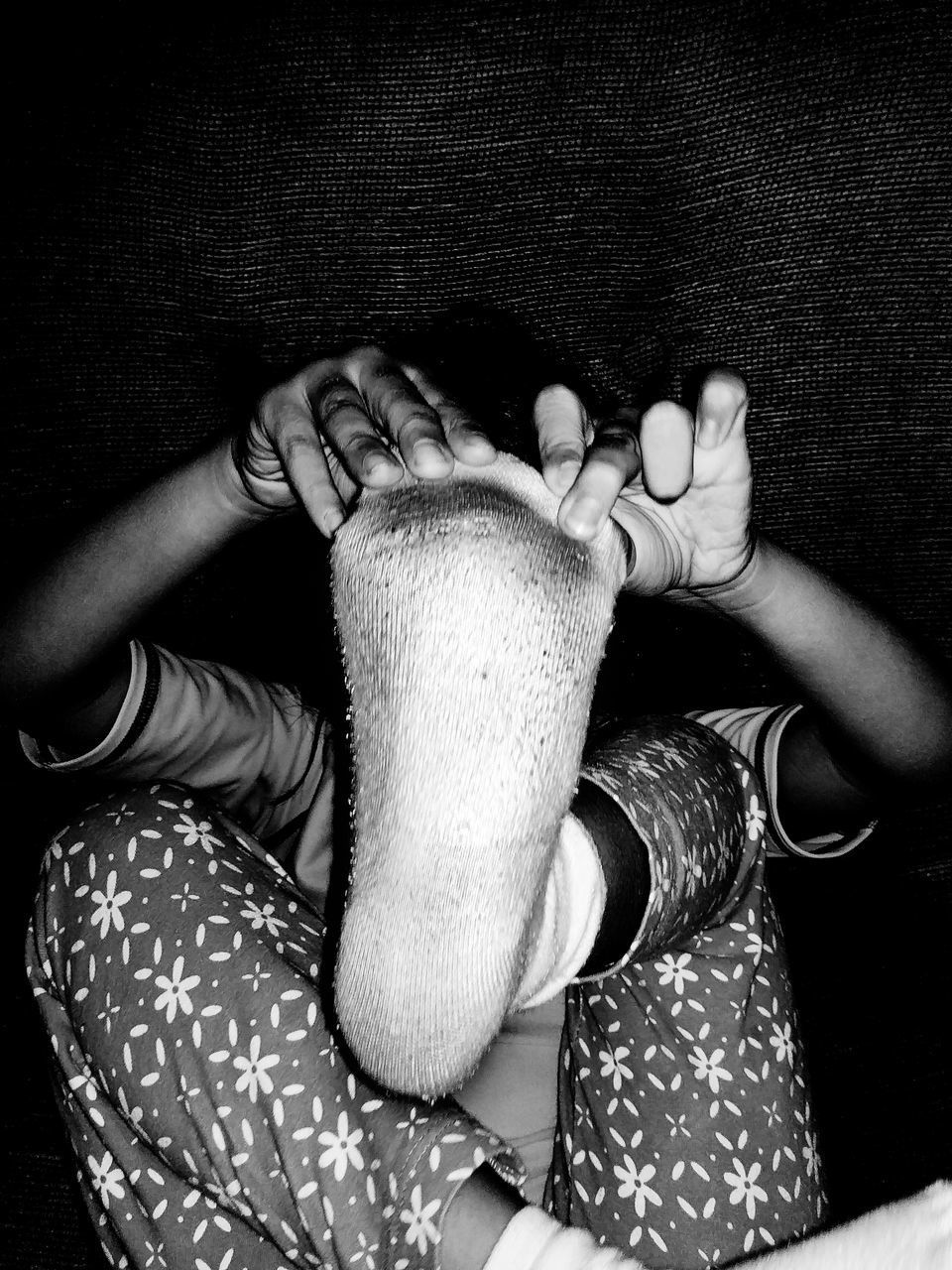 HIGH ANGLE VIEW OF HANDS AND WOMAN RELAXING ON BED AT HOME