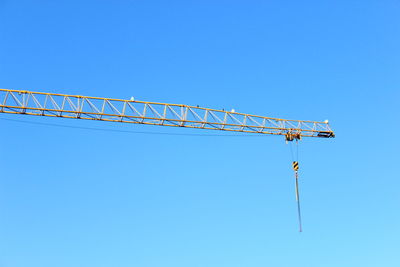 Low angle view of power lines against clear blue sky