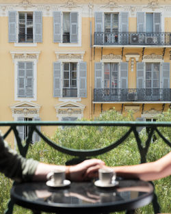 Close up of couple holdings hands during coffee on a balcony in the south of france