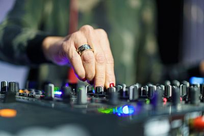 Midsection of woman operating sound mixer