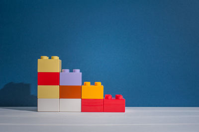 Multi colored toy on table against blue background