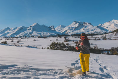 Full length of woman standing on snow covered mountains
